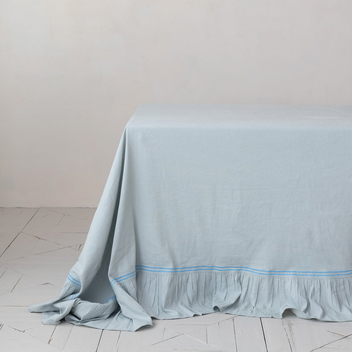 light blue table runner with blue trim covering a table