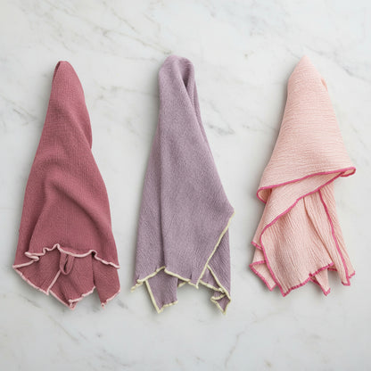 3 assorted color towels draped on a marble surface