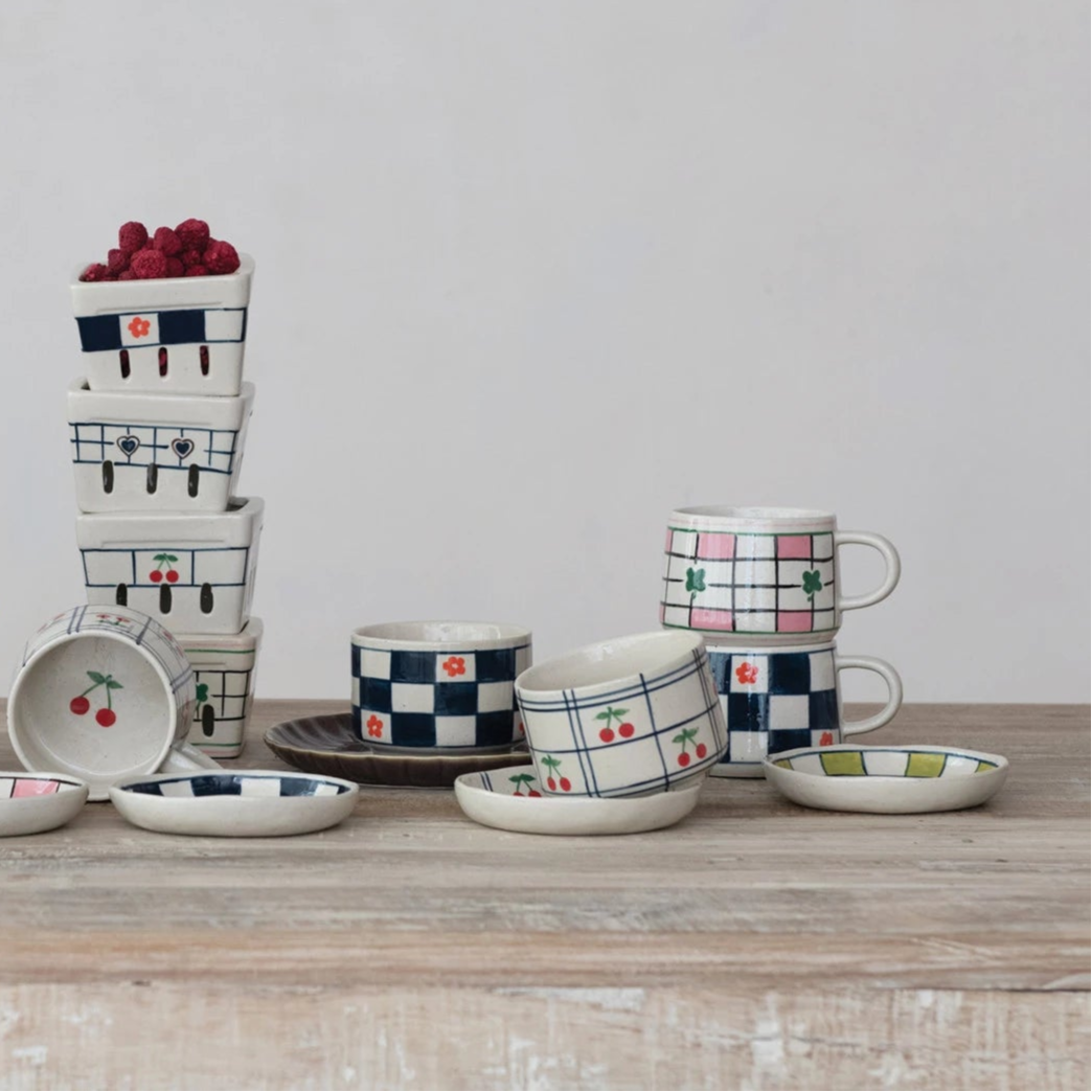 ceramic cups  with checkered and patterned designs on a wooden surface.