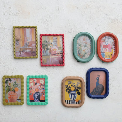 colorful picture frames with various designs on a white plaster wall.