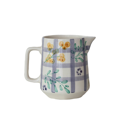Ceramic pitcher with floral and plaid design on a white background