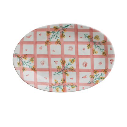 top view of pink plaid and floral platter on a white background