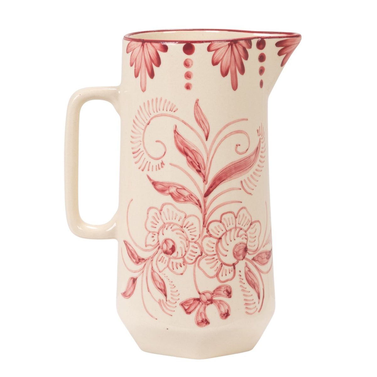An off-white ceramic pitcher decorated with a dusty red floral and scroll pattern, featuring a side handle and a small pouring spout, set against a plain white background.