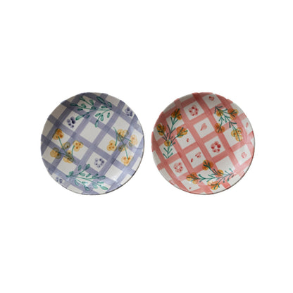 2 plates with plaid and floral design on a white background