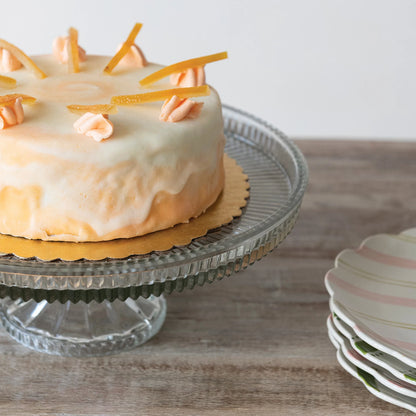 Decorative cake on a glass cake stand with a neutral background