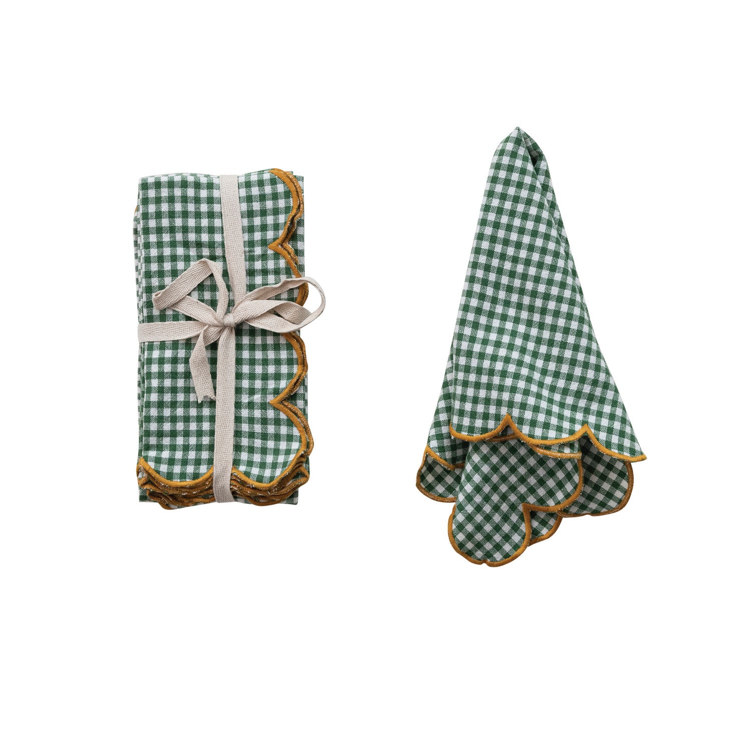 Green checkered napkin with yellow trim draped on the right and set of napkins tied with ribbon on left
