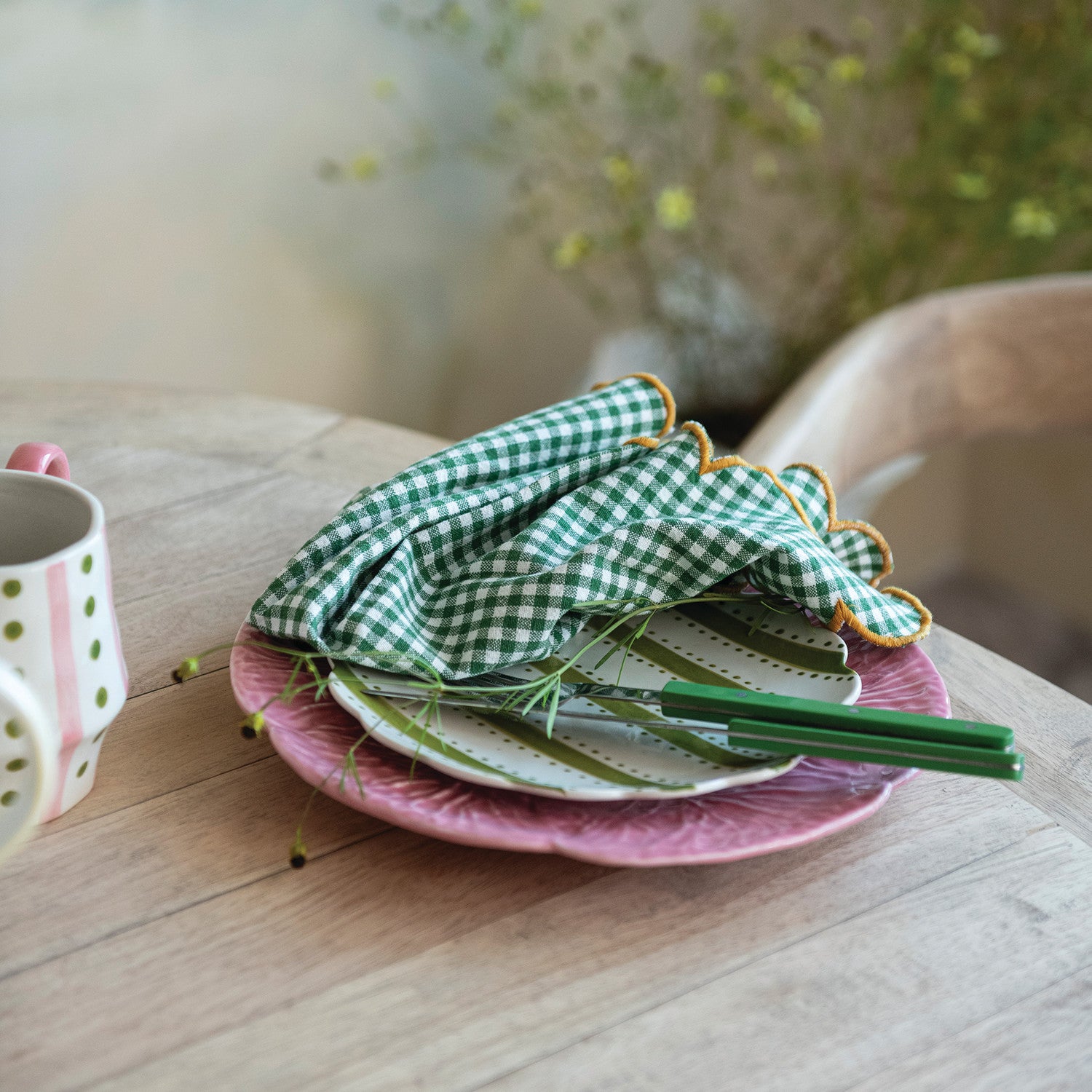 Green checkered napkin on a pink plate with a blurred background