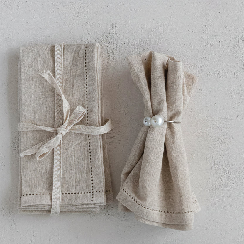 Set of natural cotton napkins with decorative elements on a light gray background