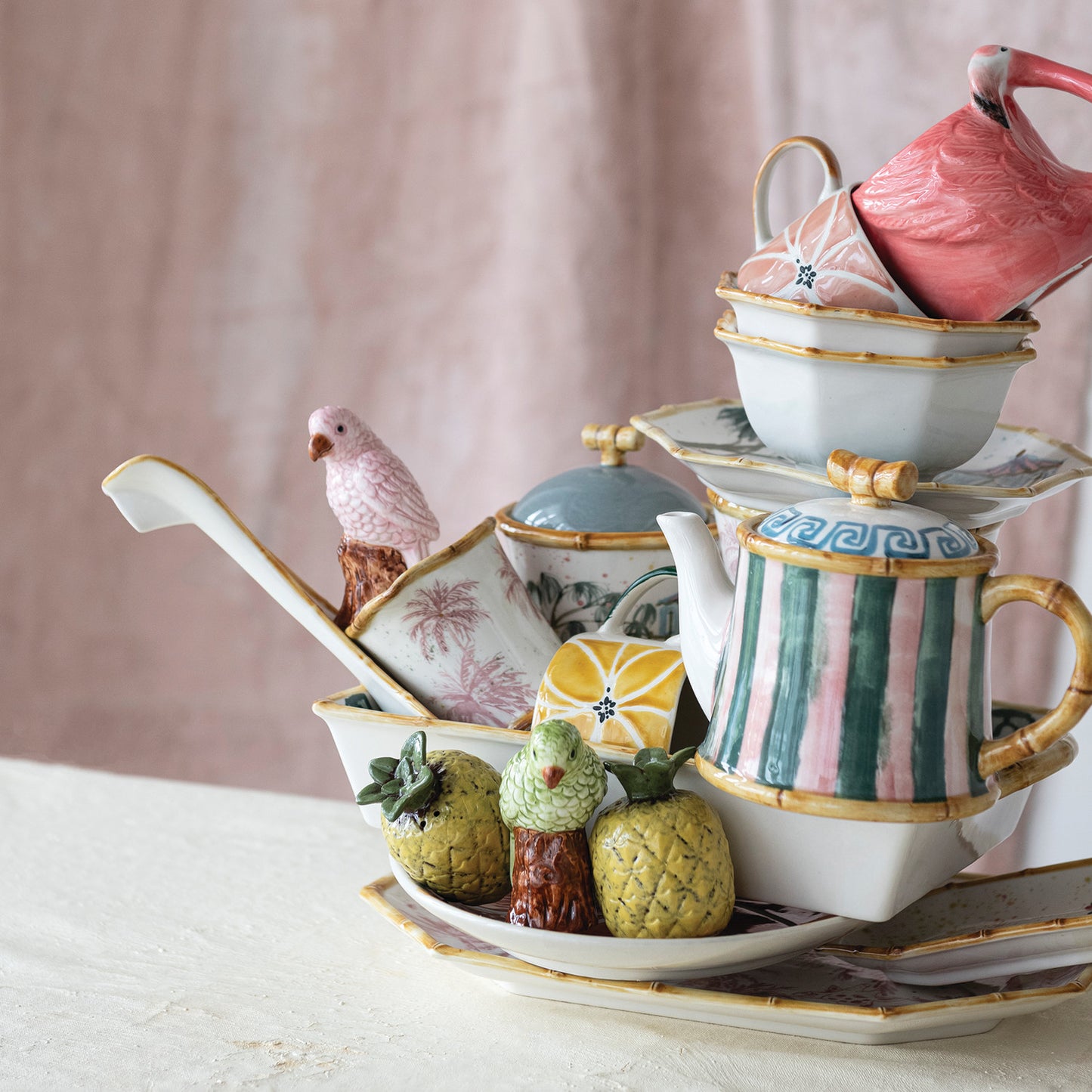 striped tea pot sitting on a pile of ceramics