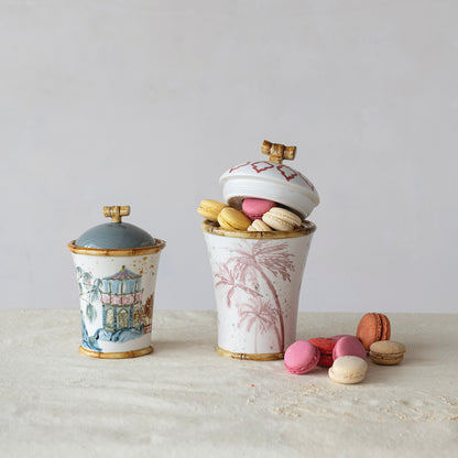 Decorative ceramic canisters with lids and macarons on a light surface.