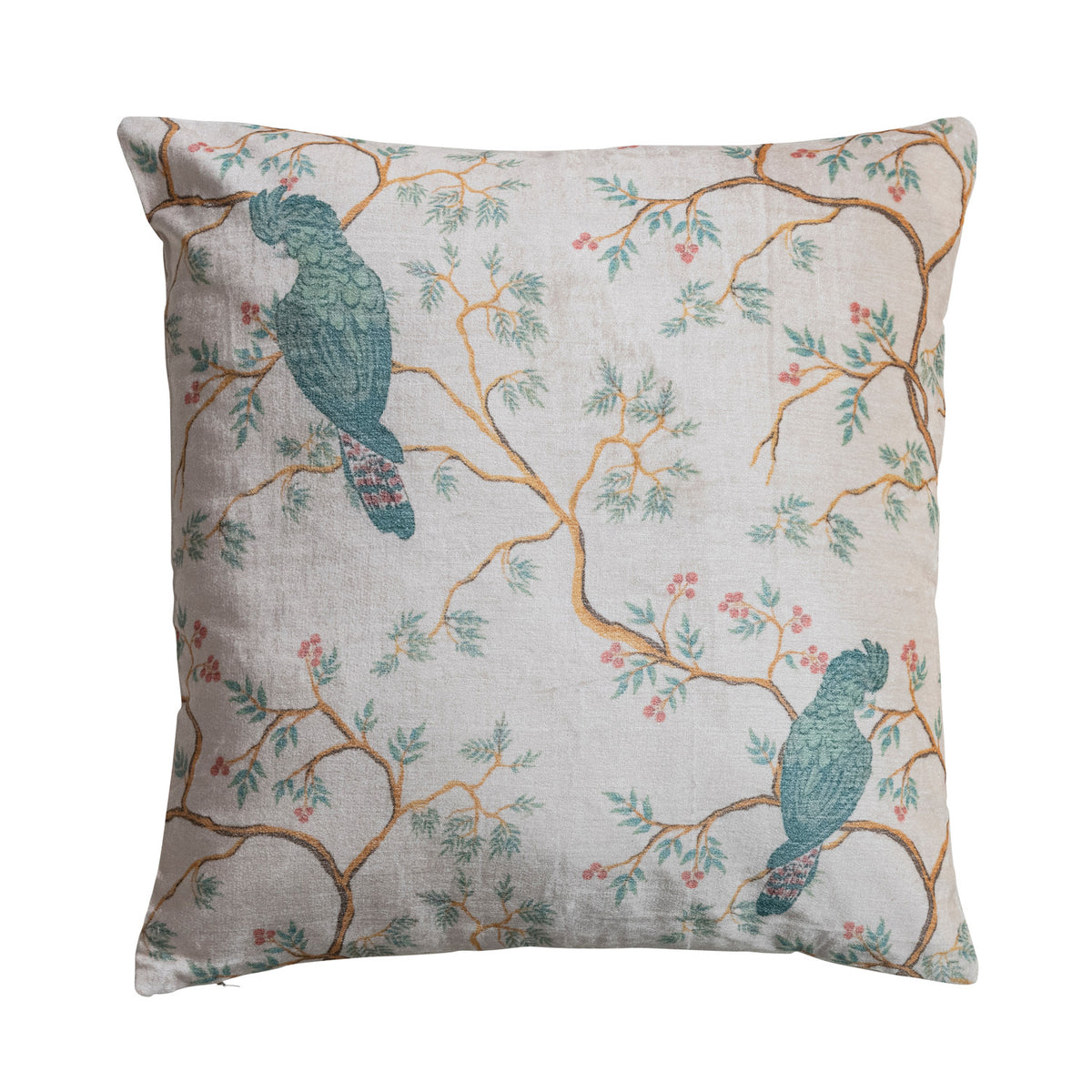 cream colored velvet pillow with airy branch design and blue parrot-like birds perched on them
