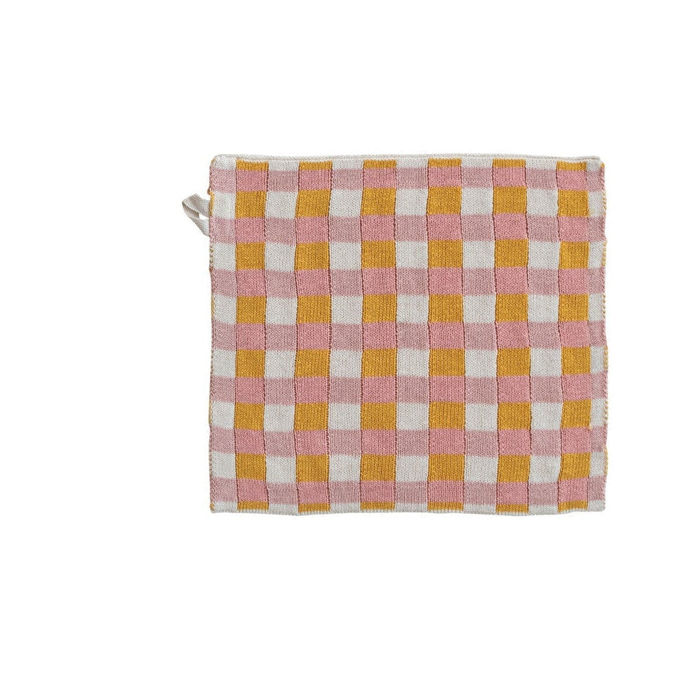 Checkered dishcloth with pink, yellow, and white pattern on a white background
