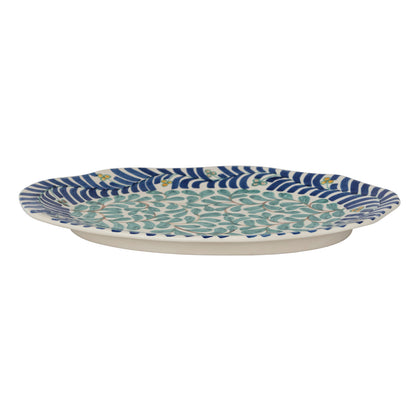 side view of Decorative ceramic platter with blue and green pattern on a white background