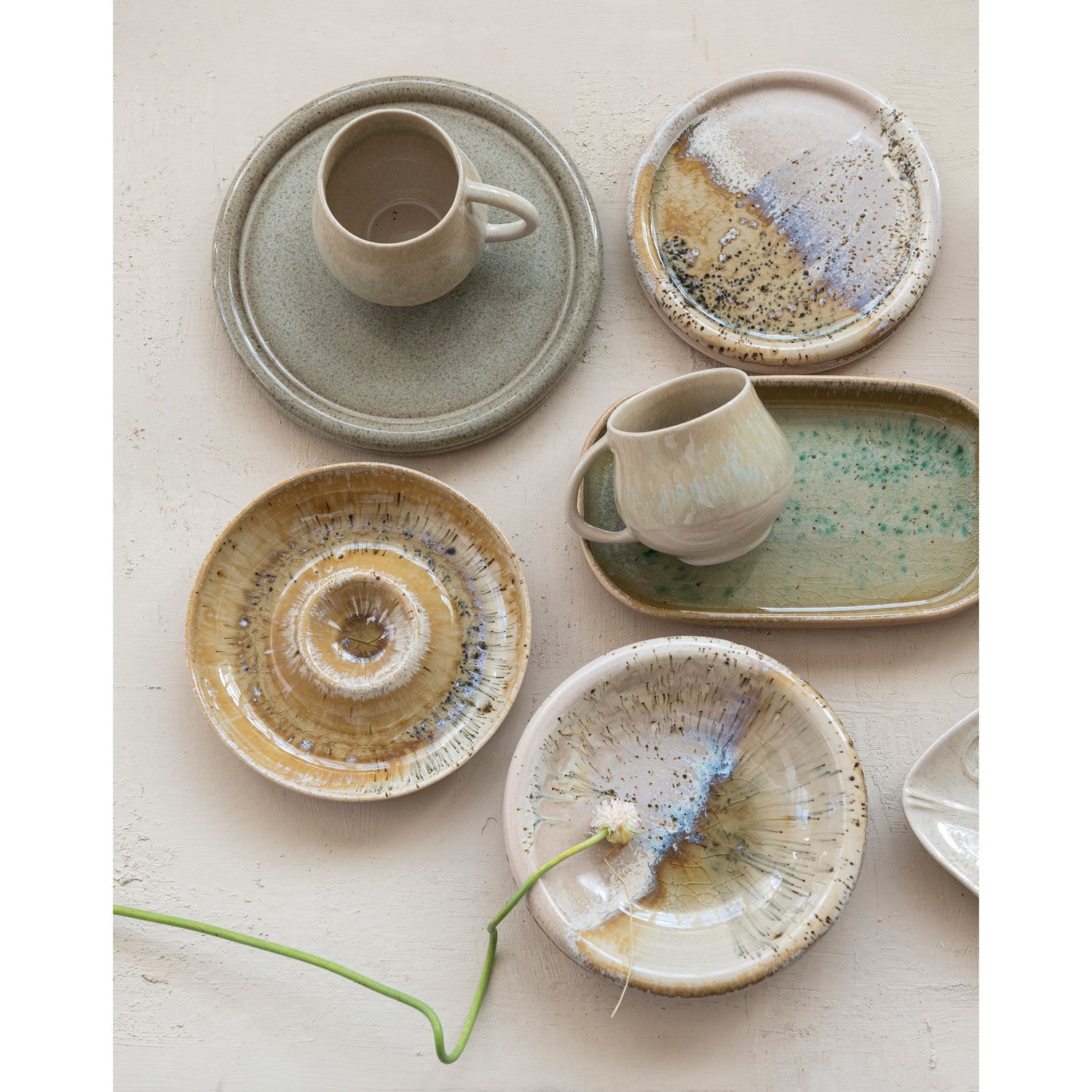 Set of ceramic dishes with speckled glaze on a light background