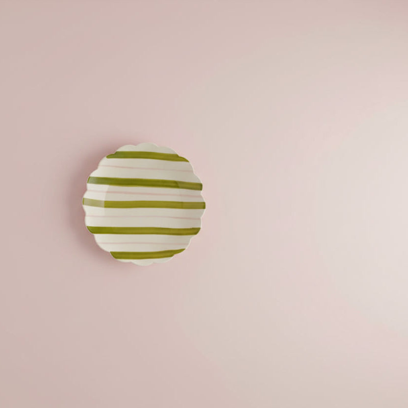 plate with green and pink stripes  shown on pale pink background