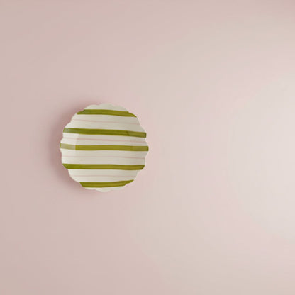 plate with green and pink stripes  shown on pale pink background