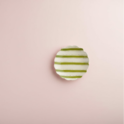 plate with green stripes and dots shown on pale pink background