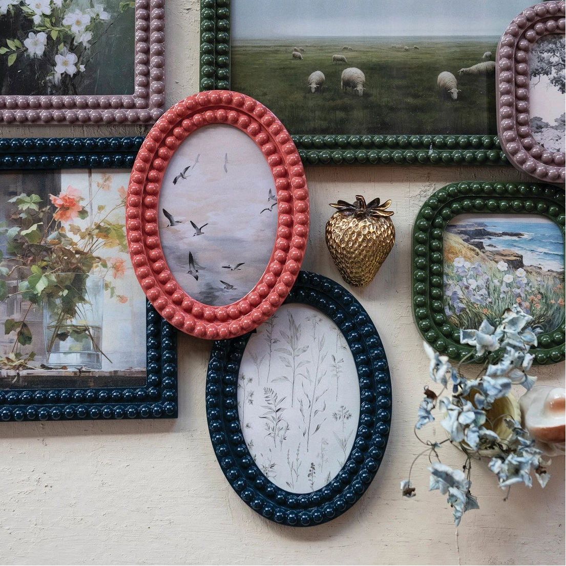 Collection of decorative picture frames with various photos on a textured wall.