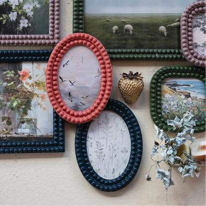 Collection of decorative picture frames with various photos on a textured wall.