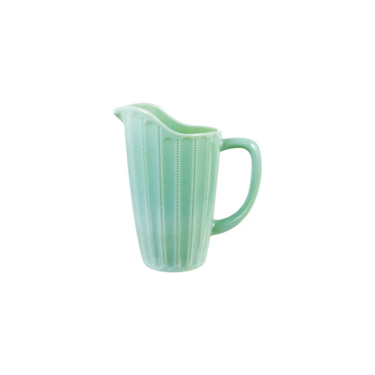 A mint green glass pitcher with a ribbed vertical texture and a curved handle, shown on a plain white background.
