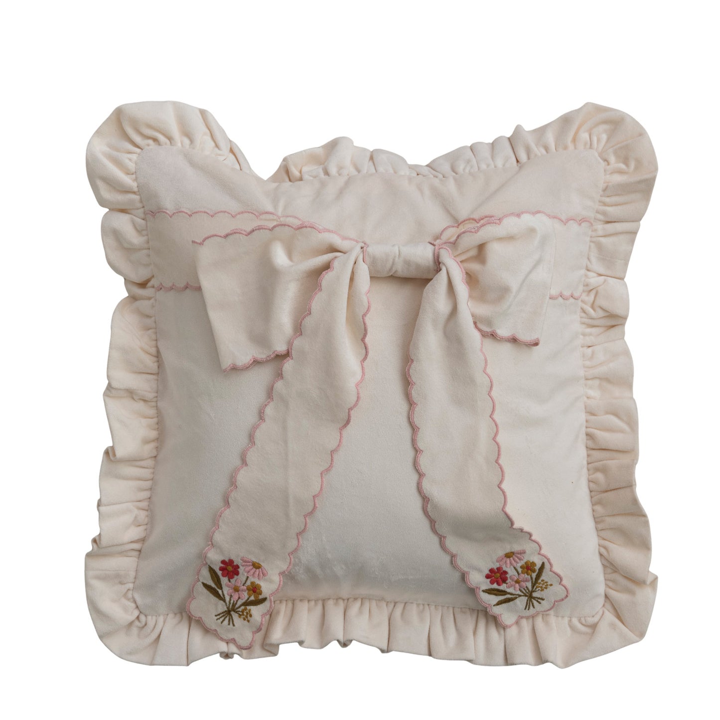 off-white pillow with ruffled trim and oversized bow on, bow has pink scalloped edge and embroidered pink florals on each end