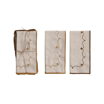 embroidered napkins with decorative patterns folded on a white background