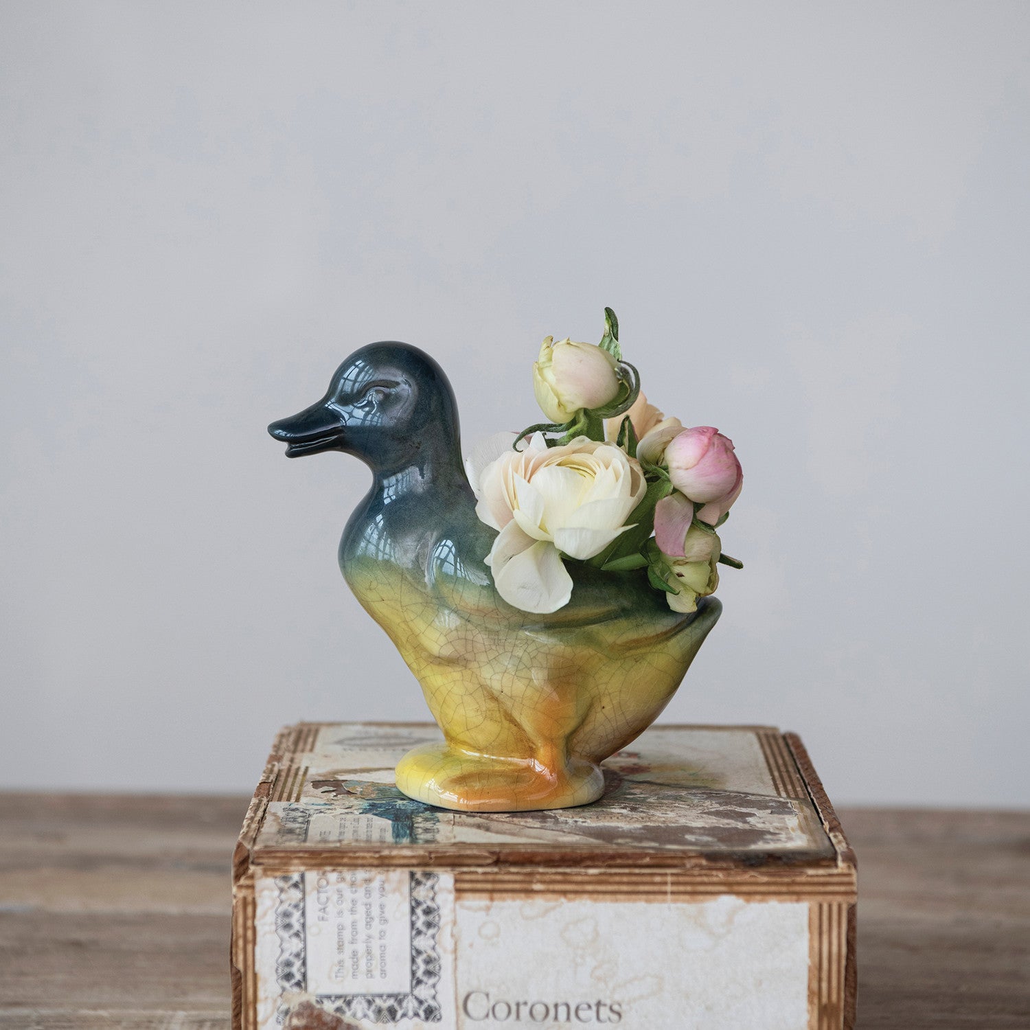Vintage Reproduction Duck Shaped Vase on a decorative box with flowers in it