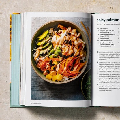 Open cookbook showing a recipe for spicy salmon dish on a beige surface