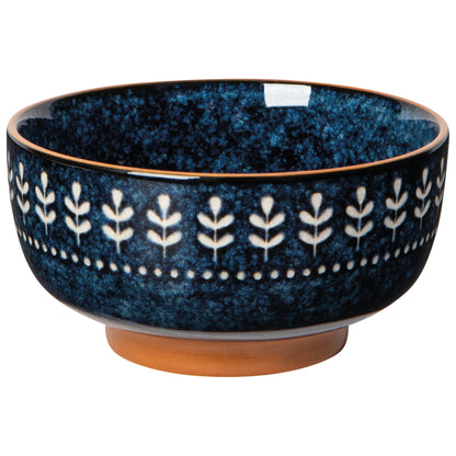 A small, round, blue stoneware bowl with a floral radial pattern on the perimeter.