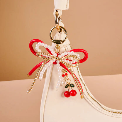 cherry bliss Layered Bows Bag Charm hung on a white purse