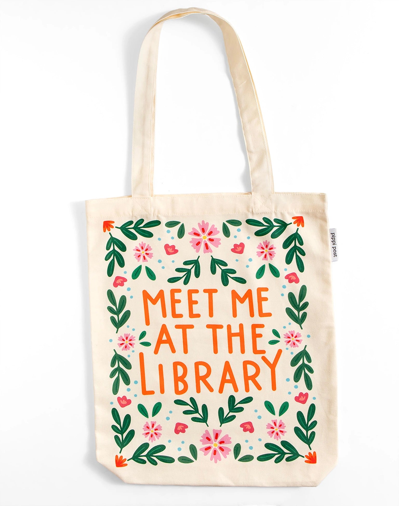 Tote bag with 'Meet Me at the Library' text and floral design on a white background