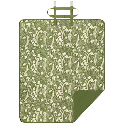 picnic blanket laying flat with one corner flapped over showing one side solid green and the other side green with cream leaves and fern design