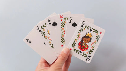 hand holding cards showing queen, king, and number cards