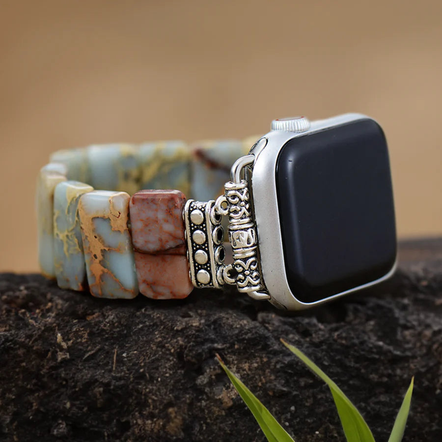 tibetan jasper stretch watch strap set on a rock with leaves in front of it.