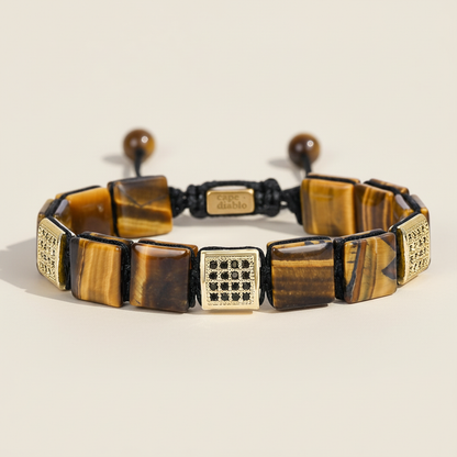 Bracelet with tiger eye stones and gold accents on a beige background