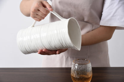 pitcher being held and pouring into a cup