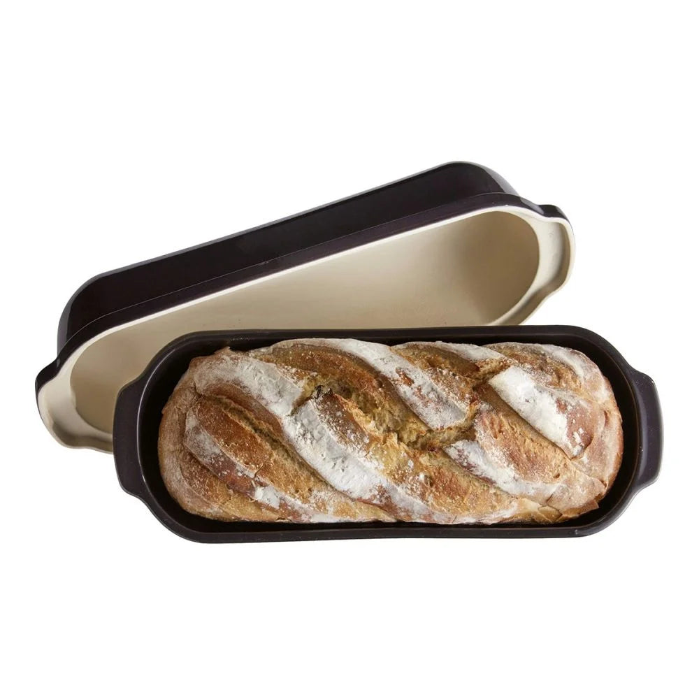 top view of long loaf baker with baked bread in it shown on a white background.