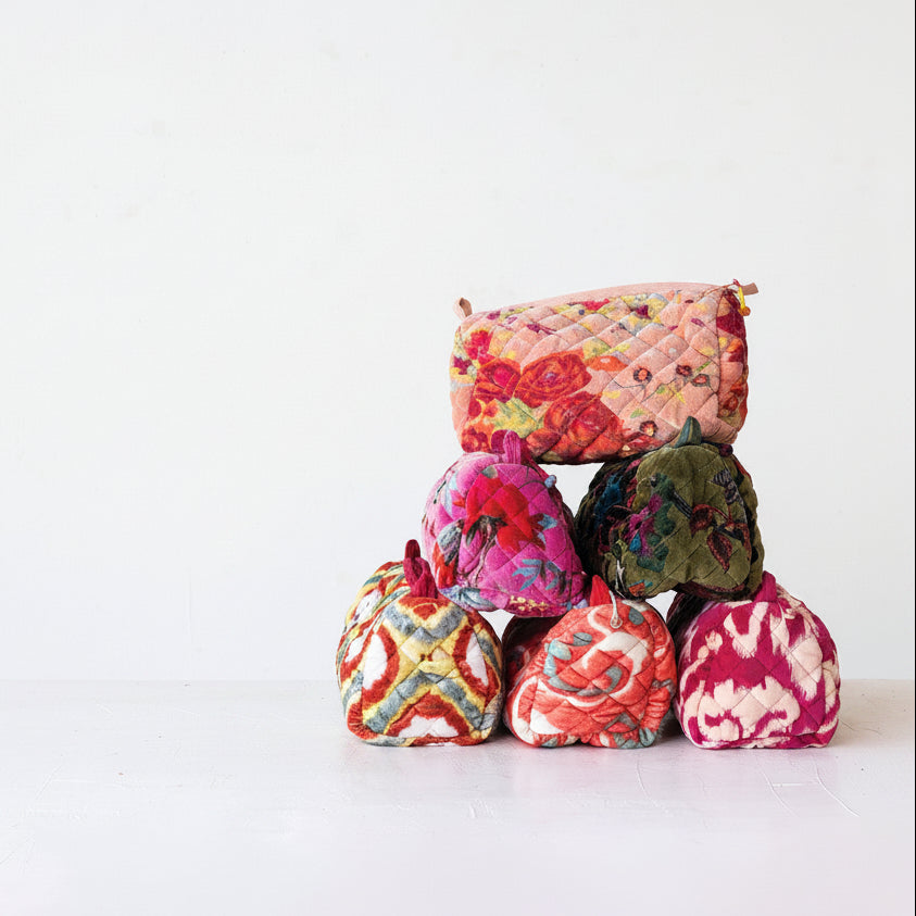 Colorful fabric pouches stacked on a white background