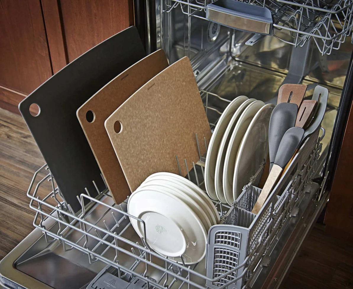 several epicurean cutting boards in a dishwasher with other dishes.