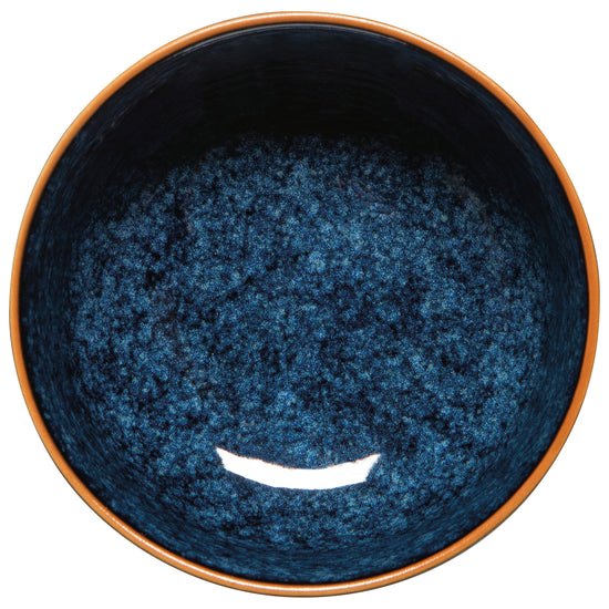 top view of Blue ceramic bowl with brown rim on white background