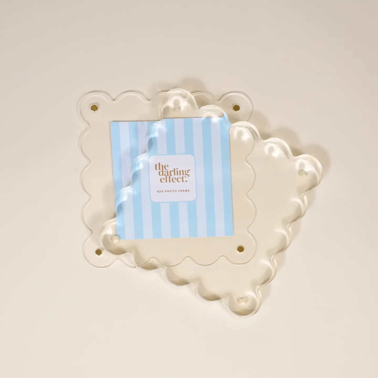 Decorative white frame with a blue and white striped card inside separated to show how to swap out photos