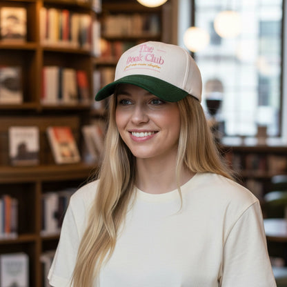 person wearing a cap with 'The Book Club' text in a bookstore setting