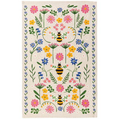 tan towel covered in yellow, blue, and pink flowers, with bees