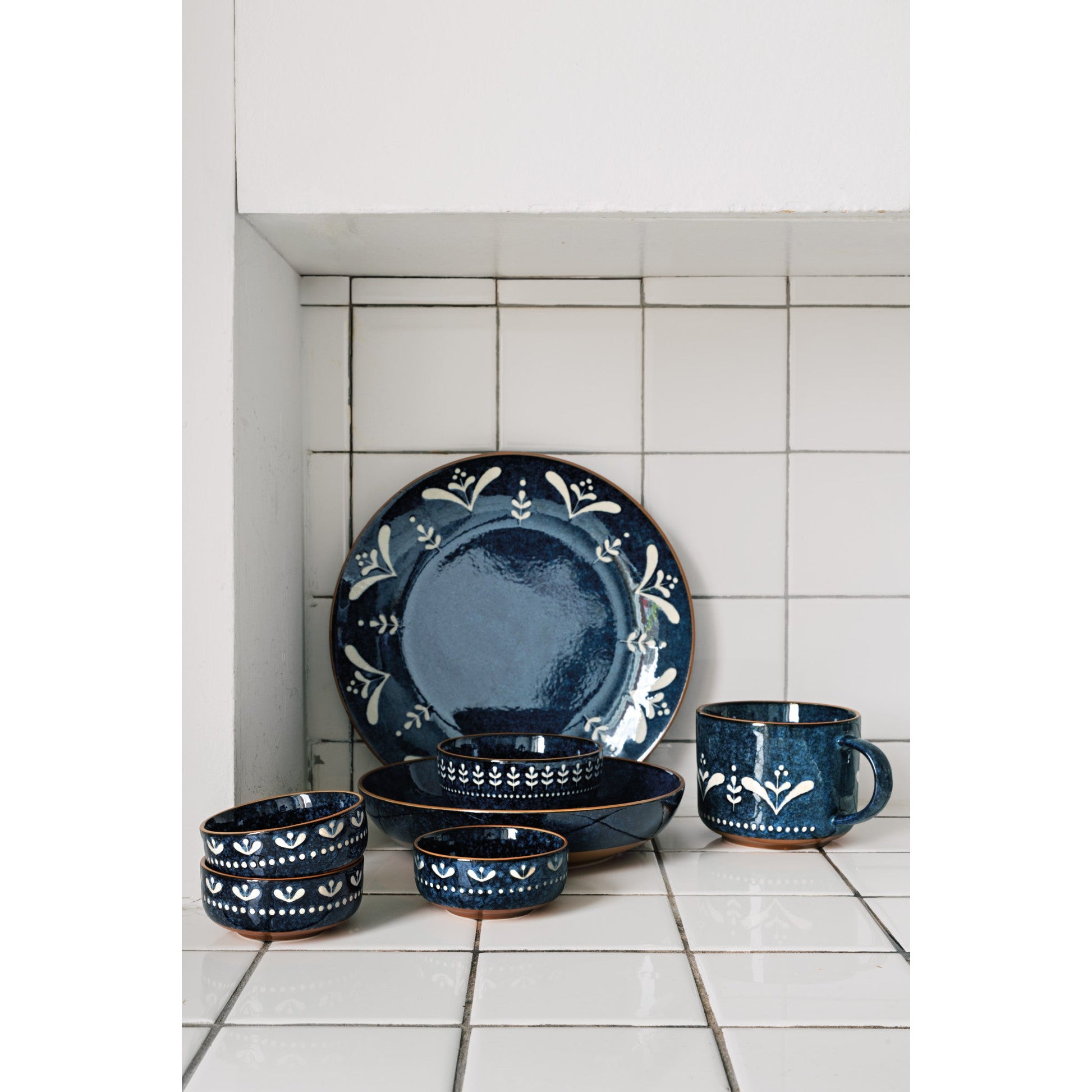Blue ceramic dishes on tiled countertop