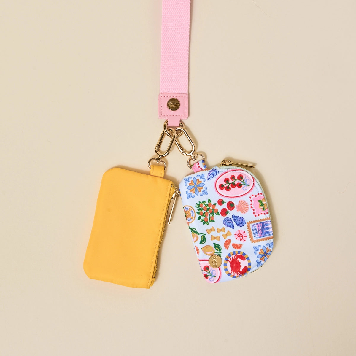 Two small pouches, one yellow and one with a colorful pattern, on a beige background.