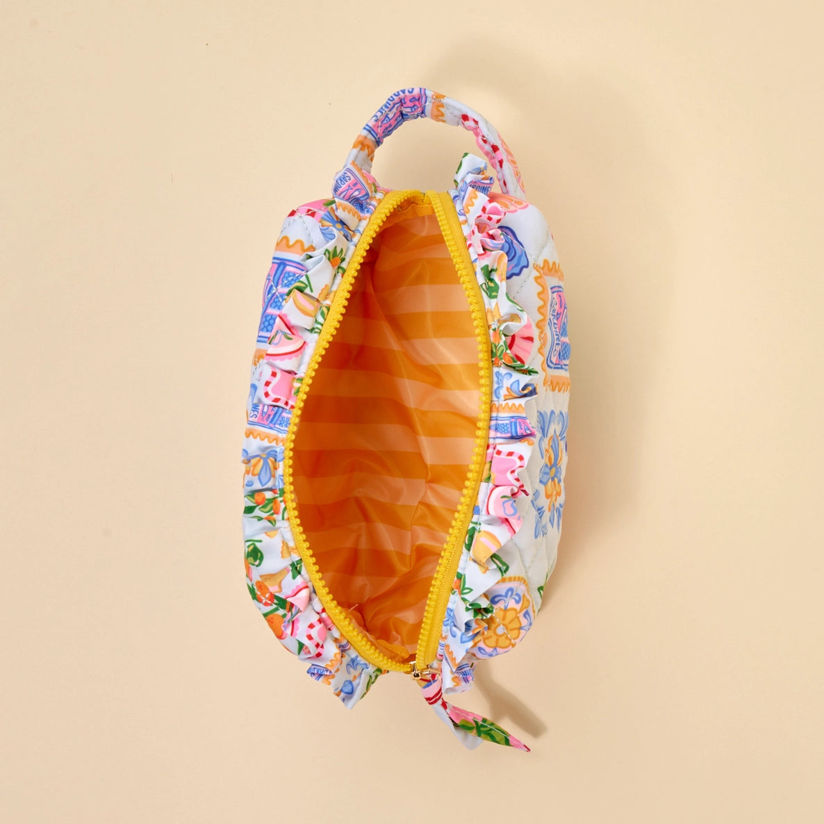 Floral-patterned pouch with a yellow zipper and interior  on a beige background