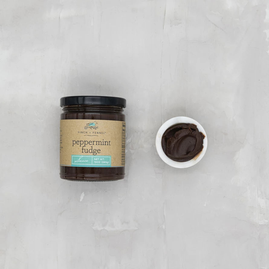 jar of Peppermint Fudge Sauce with a bowl of it set next to it.