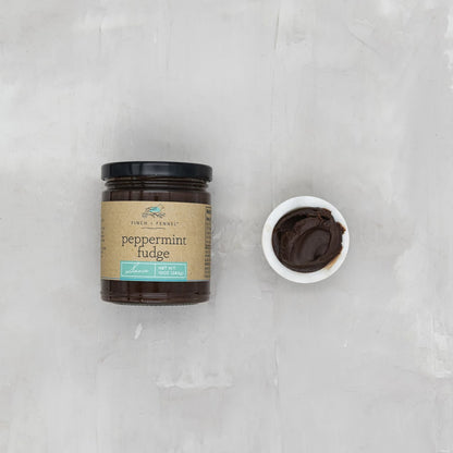 jar of Peppermint Fudge Sauce with a bowl of it set next to it.