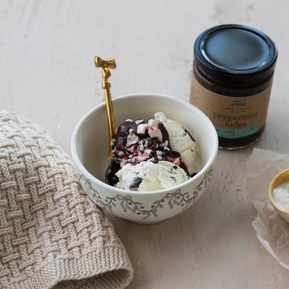 jar of Peppermint Fudge Sauce set next to a bowl of ice cream topped with Peppermint Fudge Sauce