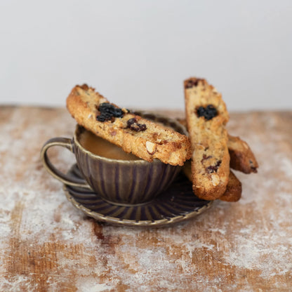 mug of coffee and 2 pieces of biscotti with Cherry Vanilla Fruit Preserves on them